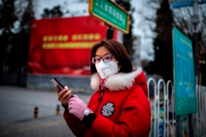 OMS desmiente teoría conspirativa de que el Coronavirus salió de laboratorio 1 Mujer mascarilla telefono FE